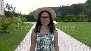 戴着帽子和<strong>夏装</strong>的亚洲女孩微笑着沿着公园的轨道走着。 享受生活